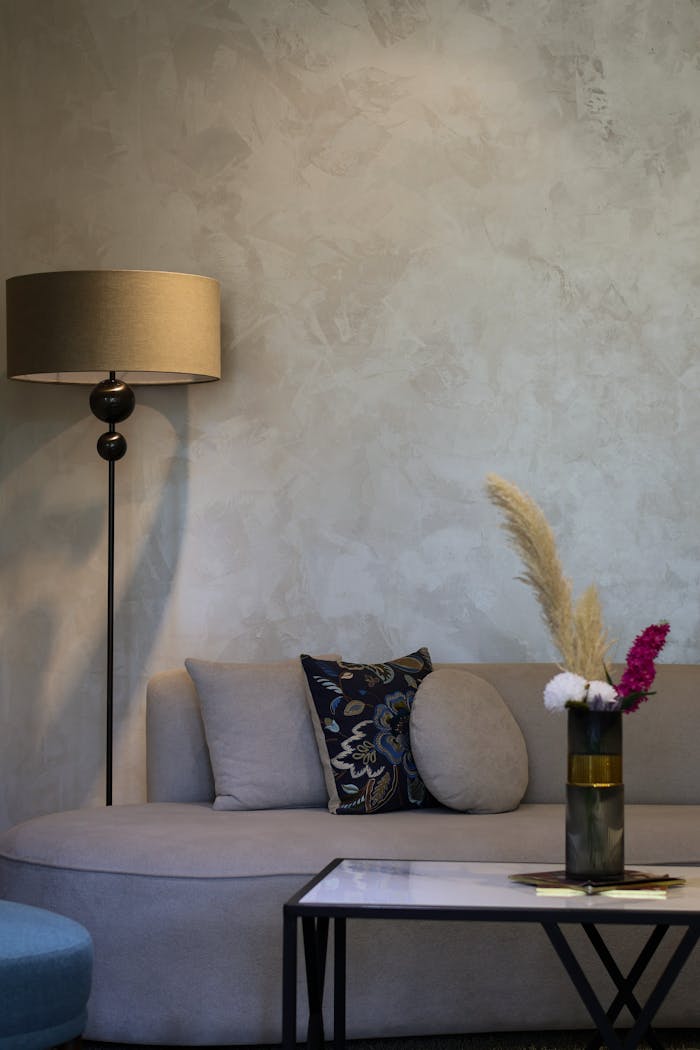 get-in-touch Elegant minimalist living room with sofa, floor lamp, and decorative vase.