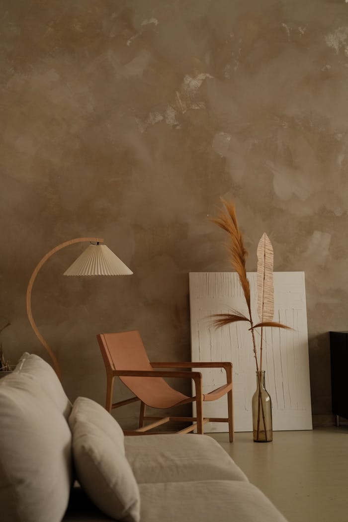 Elegant minimalist interior featuring boho decor, a leather chair, and textured walls.