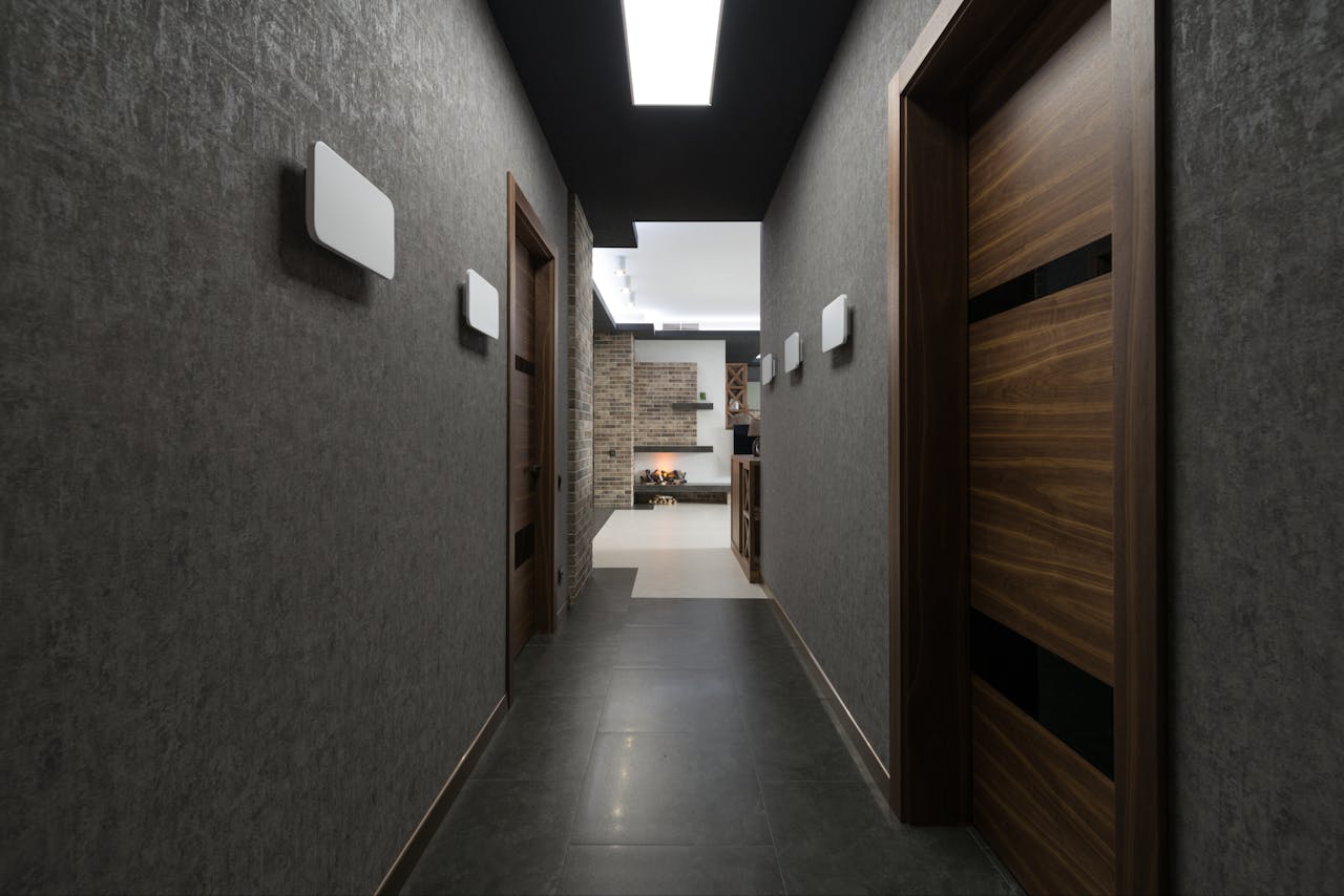 Mastering the First Impression: Your intriguing post title goes here Long corridor with gray walls and wooden doors leading to light living room with decorations at home with stylish design